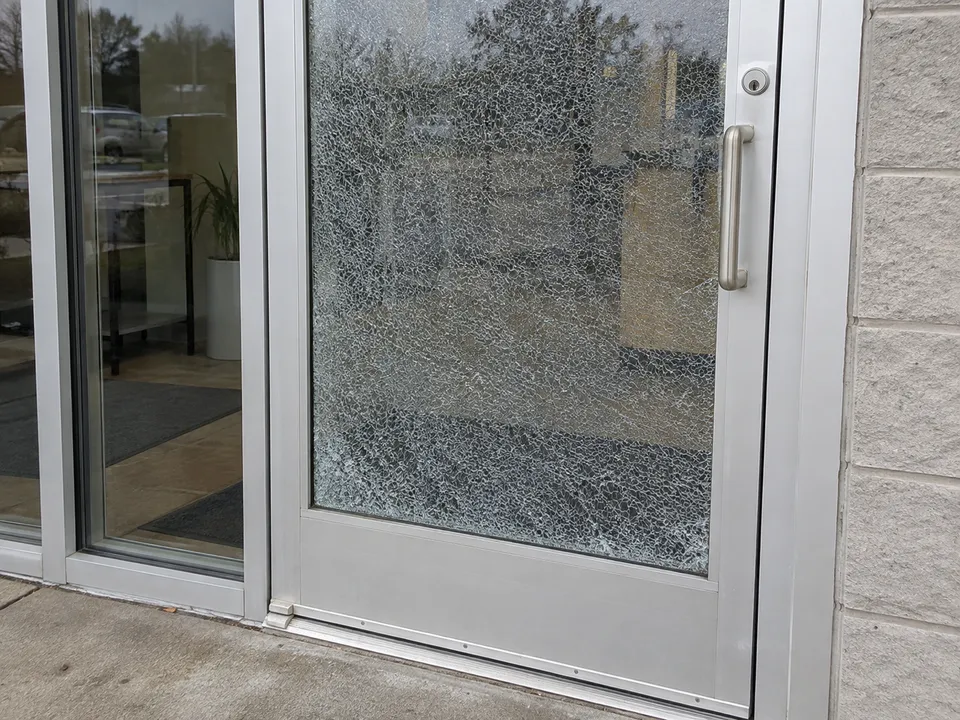 Illustration of shattered glass in an aluminum commercial entrance door