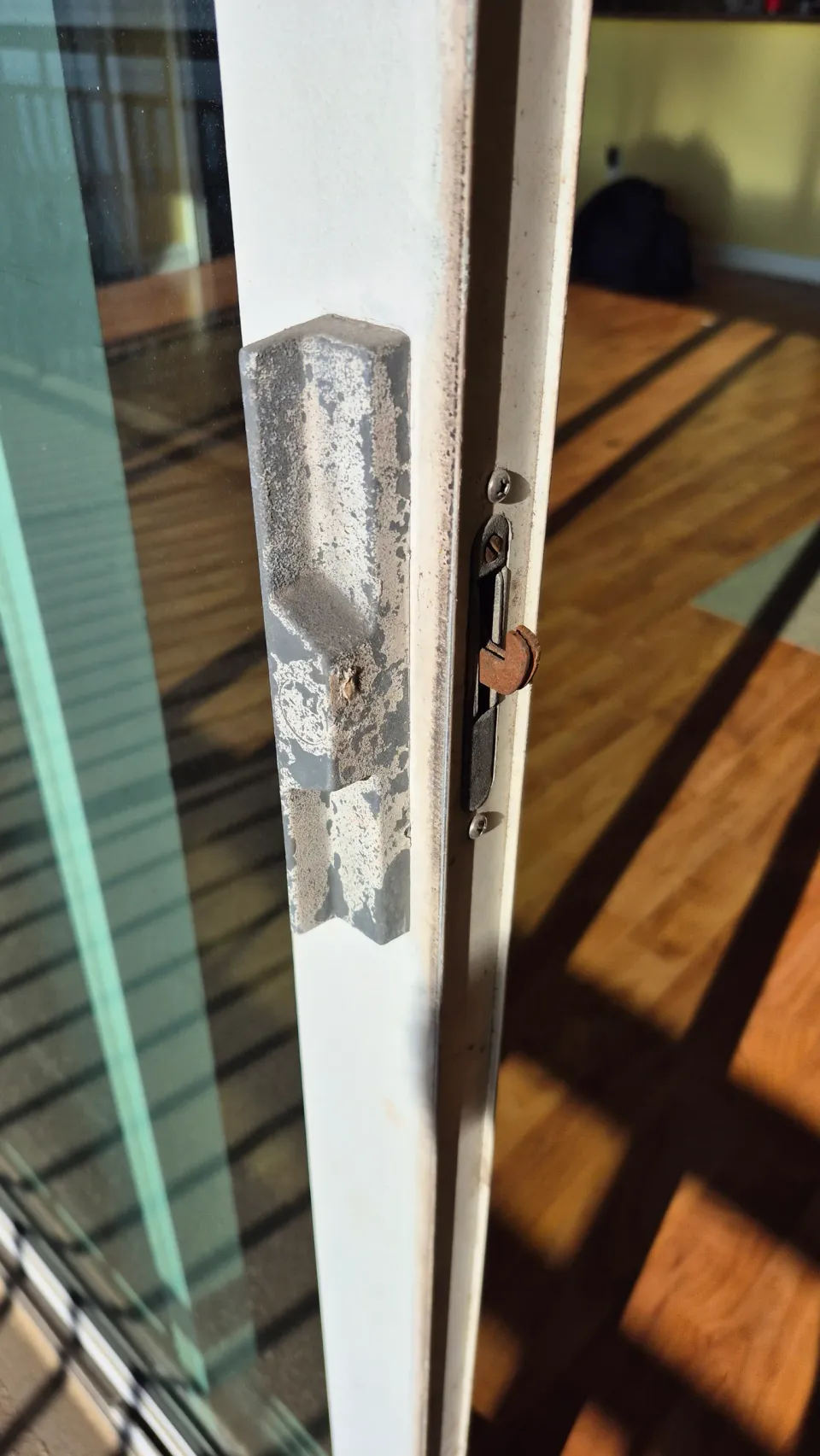 Sliding-door mortise lock with its hook latch exposed at the panel edge